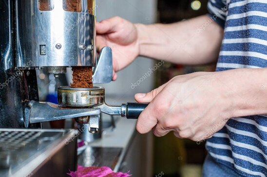 Barista cleaning a commercial coffee machine in a café