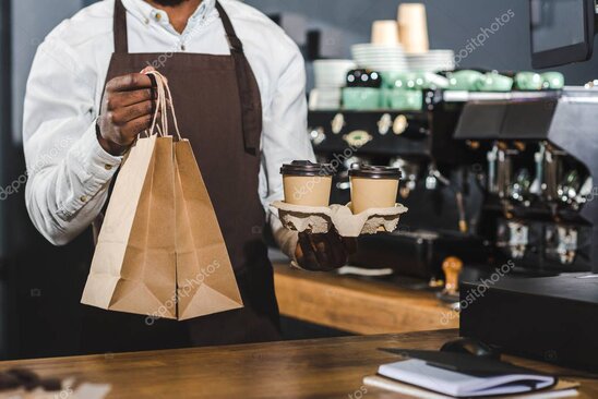 Café owner reviewing costs and savings on a laptop