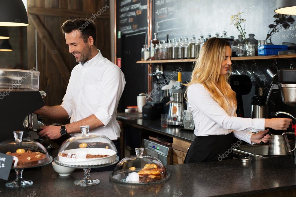 Technician talking with a team of baristas in a cafe